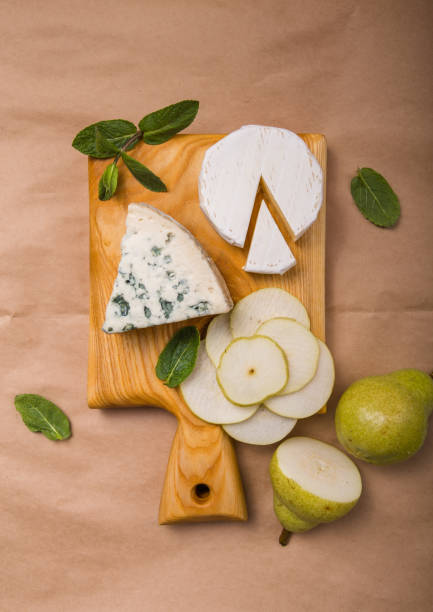 istock Segment of blue mould cheese - Gorgonzola with pear and walnuts on paper.  Top view 1222016939