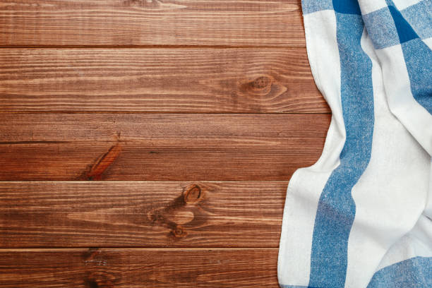 istock Top view on a dark wooden table with a linen kitchen towel or textile napkin. a tablecloth on a countertop made of old wood. Copy space for text. 1222017209