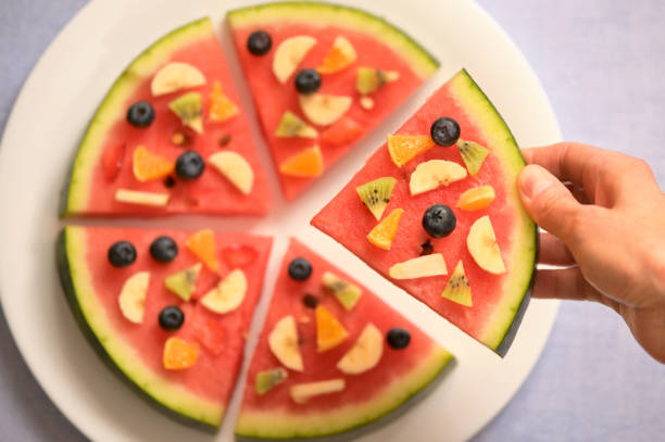 uma fatia de pizza de melancia salada de frutas exóticas - serving food fruit salad human hand - fotografias e filmes do acervo