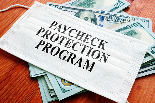 Programa de Protección de Cheques de Pago PPP como préstamo SBA escrito en la máscara y el dinero. photo