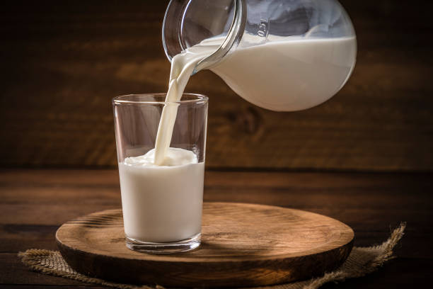 pouring milk into a drinking glass - leite imagens e fotografias de stock
