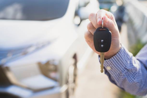 Concept image of man holding car keys front with new car. stock photo