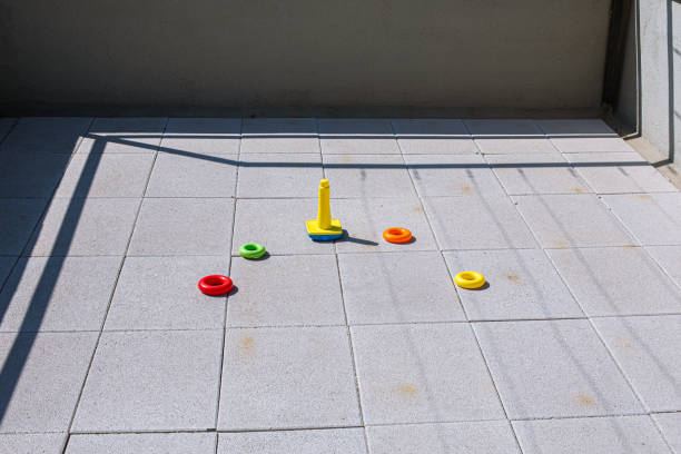 Plastic rings and cone toys making a turn on a pavement balcony