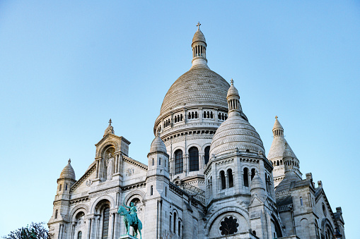 In Paris, France on a winter day the landmark Basilique Du Sacre Coeur cathedral architecture towers on top of a hill in Montmartre