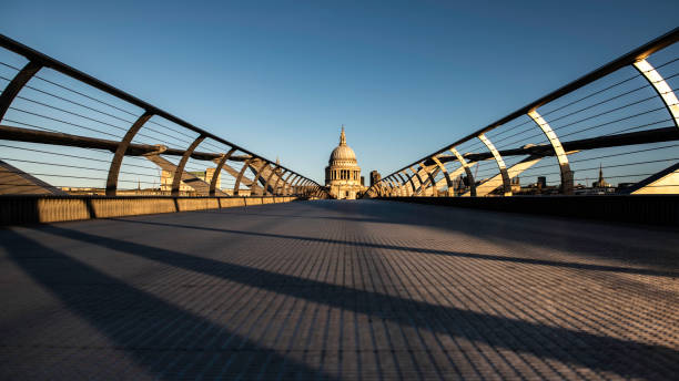 blick auf eine leere millennium-brücke in london - millennium bridge stock-fotos und bilder