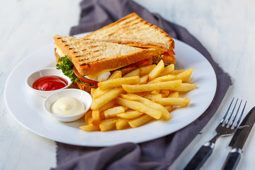Delicious club sandwich with french fries at a diner.
