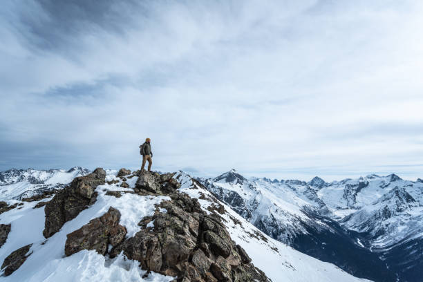 viajero en la cima de una montaña - snow hiking fotografías e imágenes de stock