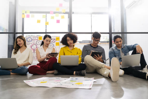 istock Group of young happy Asian creative business people or hipster student using electronic devices tablet and laptop connection together in modern office. Creative lifestyle young people concept 1222025317