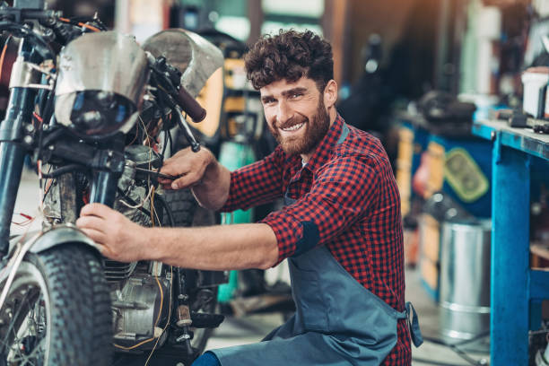 istock Cheerful young man in a motorcycle garage 1222025377