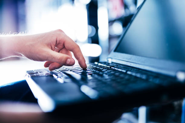 istock IT specialist pressing button on keyboard in big data center. 1222026915