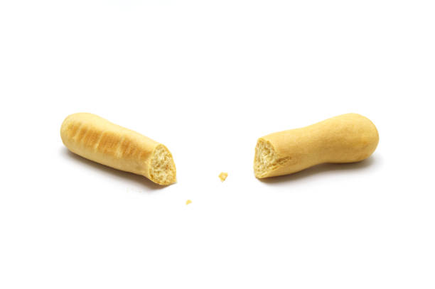 Rustic grissini bread sticks and broken with crumbs. Crispy straw biscuit isolated on white background.
