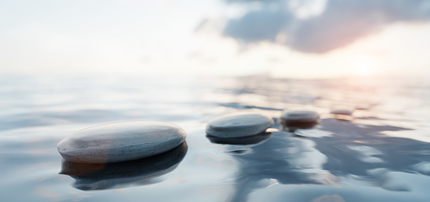 Zen stones on calm water. Spa wellness and harmony. Ocean at sunset. 3D render