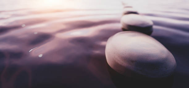 istock Zen stones on calm water at sunset. Spa wellness and harmony. 1222030617