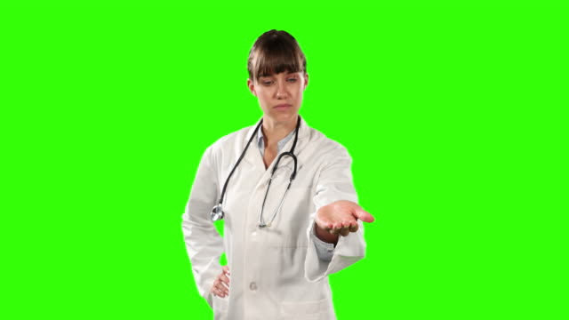 Front view of a doctor holding her hand for a copy space with green screen