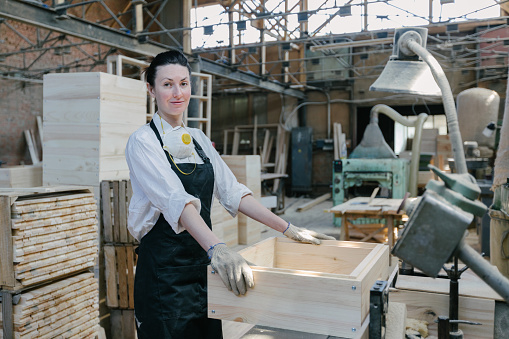 Confident woman working as carpenter in her own woodshop
