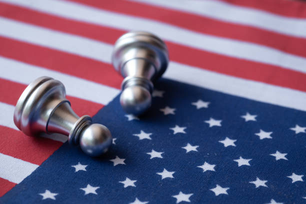 istock Chess fall down on US flag. USA economic recession because of virus outbreak. 1222032220