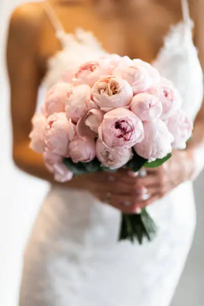 Bride hold the bouquet in her hands, selective focus on flowers
