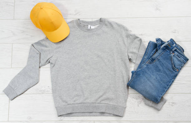 istock Yellow cap mock up, empty gray pullover copy space top view, blue denim - casual clothes background 1222035785