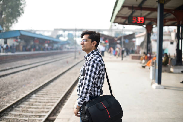 istock Man with holding bag waiting at railroad station platform 1222036525