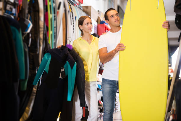 istock couple choosing surfboard in sporting goods store 1222036665