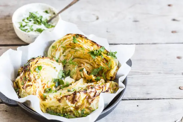 Baked cabbage slices. Vegan diet. Healthy grilled cabbage steaks with souse, spices and herbs.
