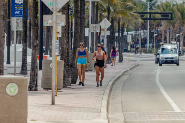 Two privileged women walking the beach sidewalk stock photo
