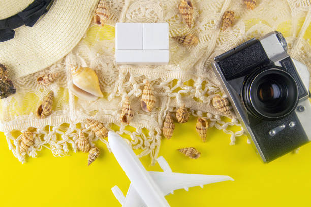 istock Summer concept. Travel accessories: a straw hat, a camera, a rope, plane, shells and wood cubes 1222040225