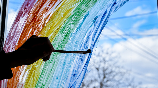 hand painting rainbow on a window, stay home during quarantine, Image of kids leisure at home, Chase the rainbow flashmob