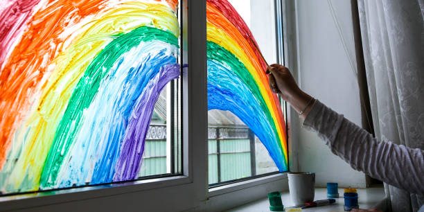 istock hand painting rainbow on a window, stay home during quarantine 1222042513