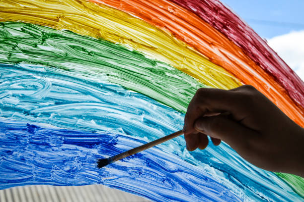 istock hand painting rainbow on a window, stay home during quarantine 1222042557