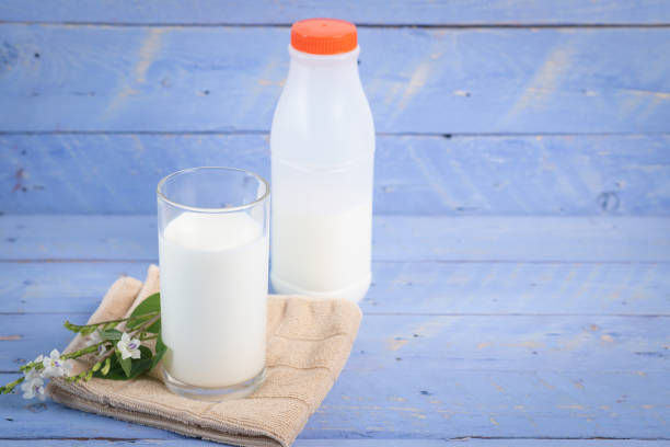 istock Milk bottle on a wooden table blue background 1222042640