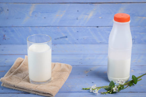 istock Milk bottle on a wooden table blue background 1222042656
