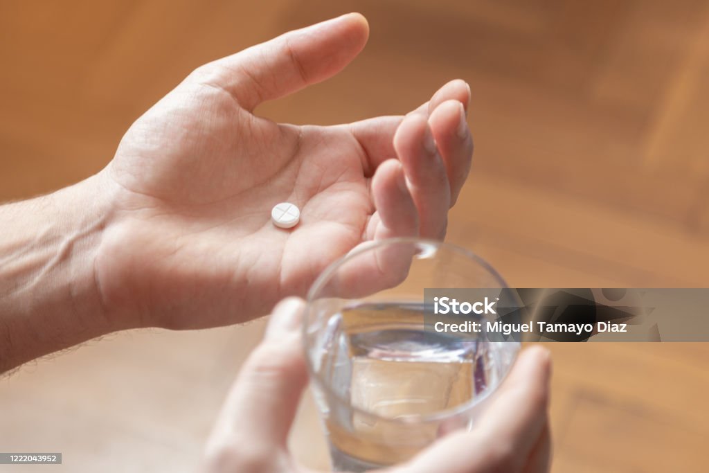 Hands holding medicine and a glass of water. Pills  and health care concept. Taking Medicine Stock Photo