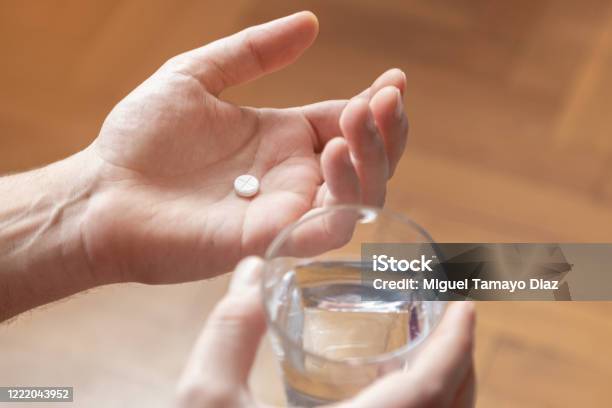Hands Holding Medicine And A Glass Of Water Pills And Health Care Concept Stock Photo - Download Image Now