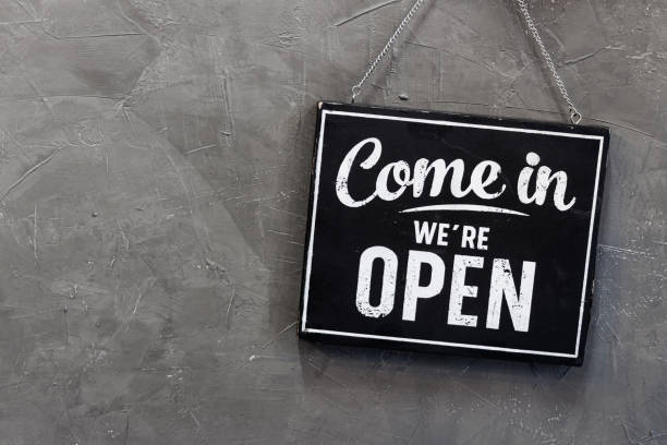 Come in we're open, vintage black retro sign in back wall