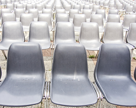 A row of empty gray chairs for outdoor cinema