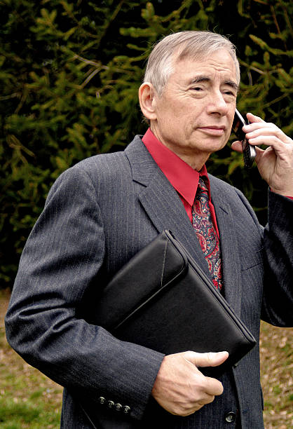 homme d'affaires sur un téléphone portable - book holding necktie businessman photos et images de collection