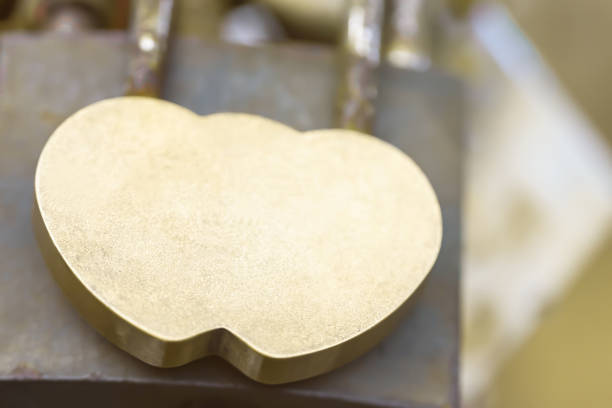 Hinged metal lock of golden color in the form of two hearts. Concept of relationship, love, marriage, wedding. Mock up, copy space.