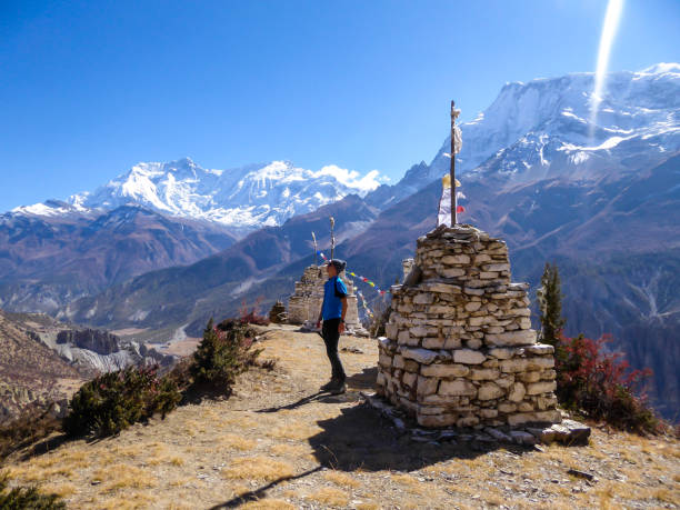 istock Praken Gompa - A man standing next to a stony stupa with Annapurna chain view 1222047277