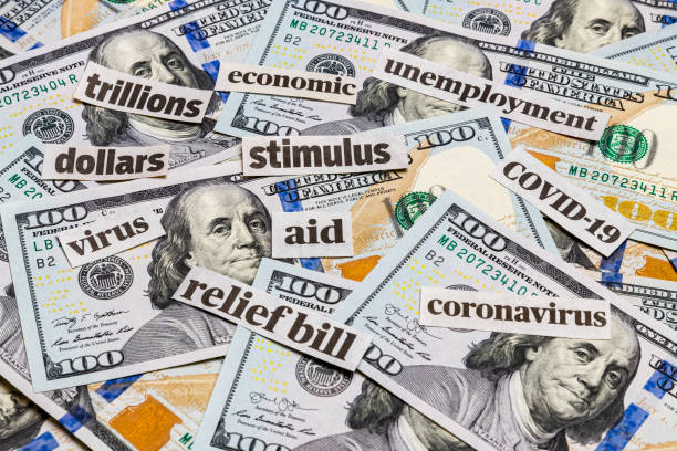 covid-19 coronavirus newspaper headlines and 100 dollar bills. stimulus aid relief bill, unemployment and recession concept - newspaper headline unemployment finance recession imagens e fotografias de stock