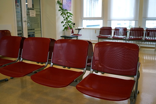 Waiting room with red chairs and beige linoleum floor