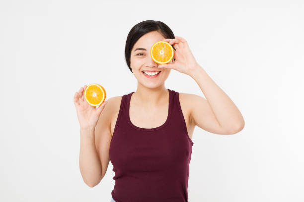 bellezza asiatica donna giapponese tenere oranges.bellezza concetto. bella ragazza adolescente gioiosa con lentiggini, divertente acconciatura rossa e trucco giallo. fetta arancione - human lips orange lipstick human mouth foto e immagini stock