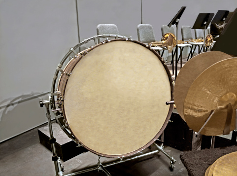 Bass drum and cymbals in foreground and French Horns in the background. 