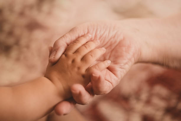 istock The child's small hand is in the old woman's. 1222052435