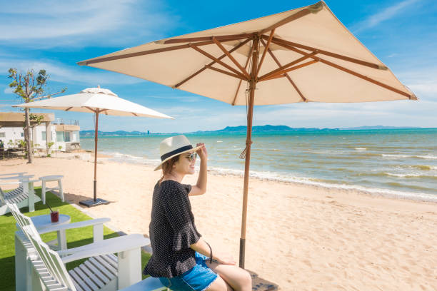 bella donna è rilassante sulla spiaggia, sotto l'ombrellone - parasol umbrella sun beach foto e immagini stock