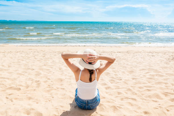 istock Beautiful woman is sitting on beach 1222053755