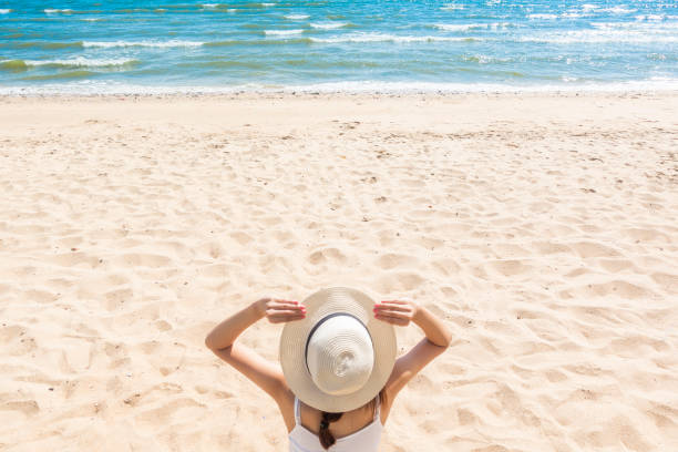 istock Beautiful woman is sitting on beach 1222053776