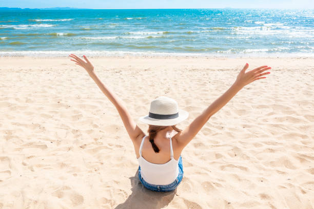 istock Beautiful woman is sitting on beach 1222053868