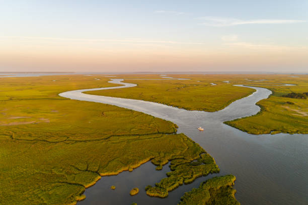 Georgia's Golden Isles at Sunset Aerial view of marsh and river just east of Brunswick, Georgia, with Saint Simons and Jekyll Islands in the distance, reflecting late-day sunlight that gives the region its "Golden Isles" nickname. saint simons island photos stock pictures, royalty-free photos & images