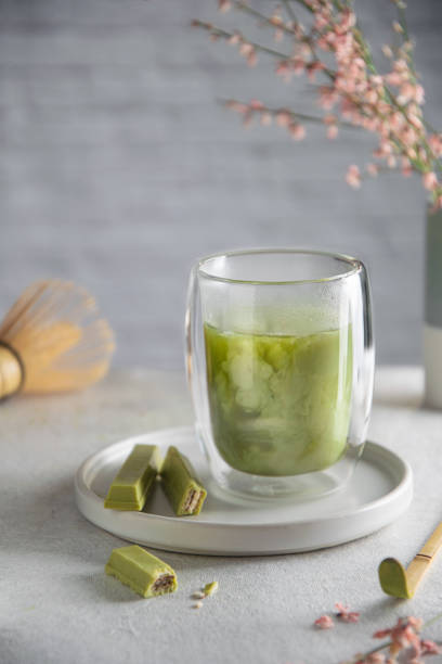 istock Glass of matcha latte with matcha chocolate on gray table 1222054411